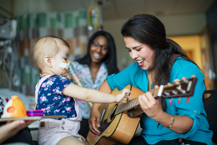 Music therapist appears with young patient.