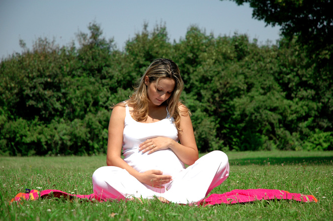 pregnant woman sitting on grass