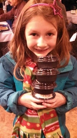 Maia smiling holding several small containers