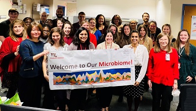 Infectious Disease fellows at Children's National holding a banner that says "Welcome to our microbiome!"