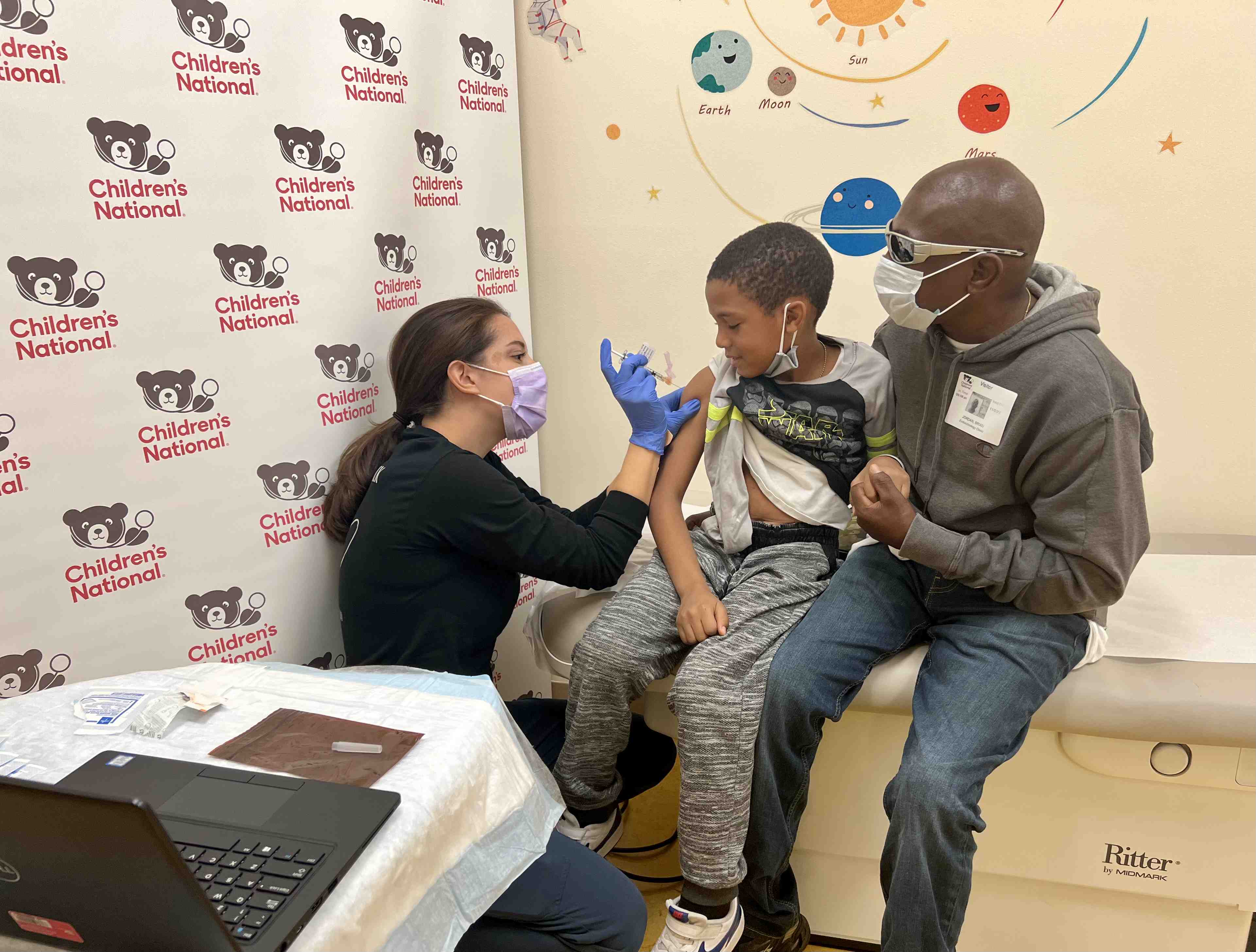Boy receiving COVID-19 vaccine from Children's National care provider