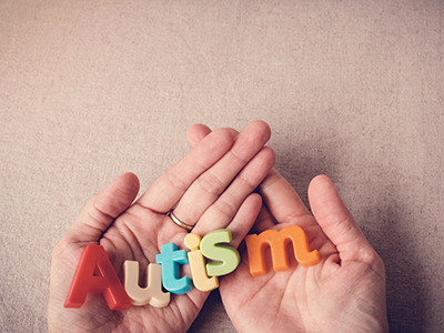 Hands holding letters that spell autism