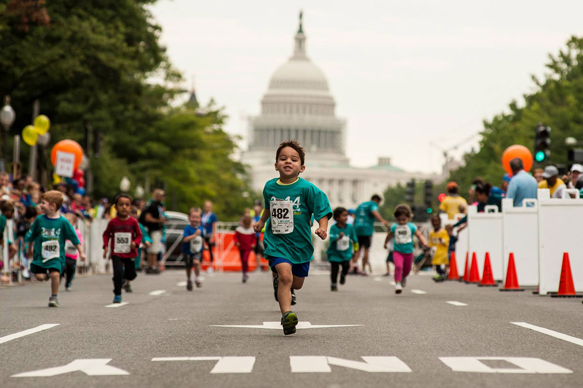 boy running with capitol building in background 